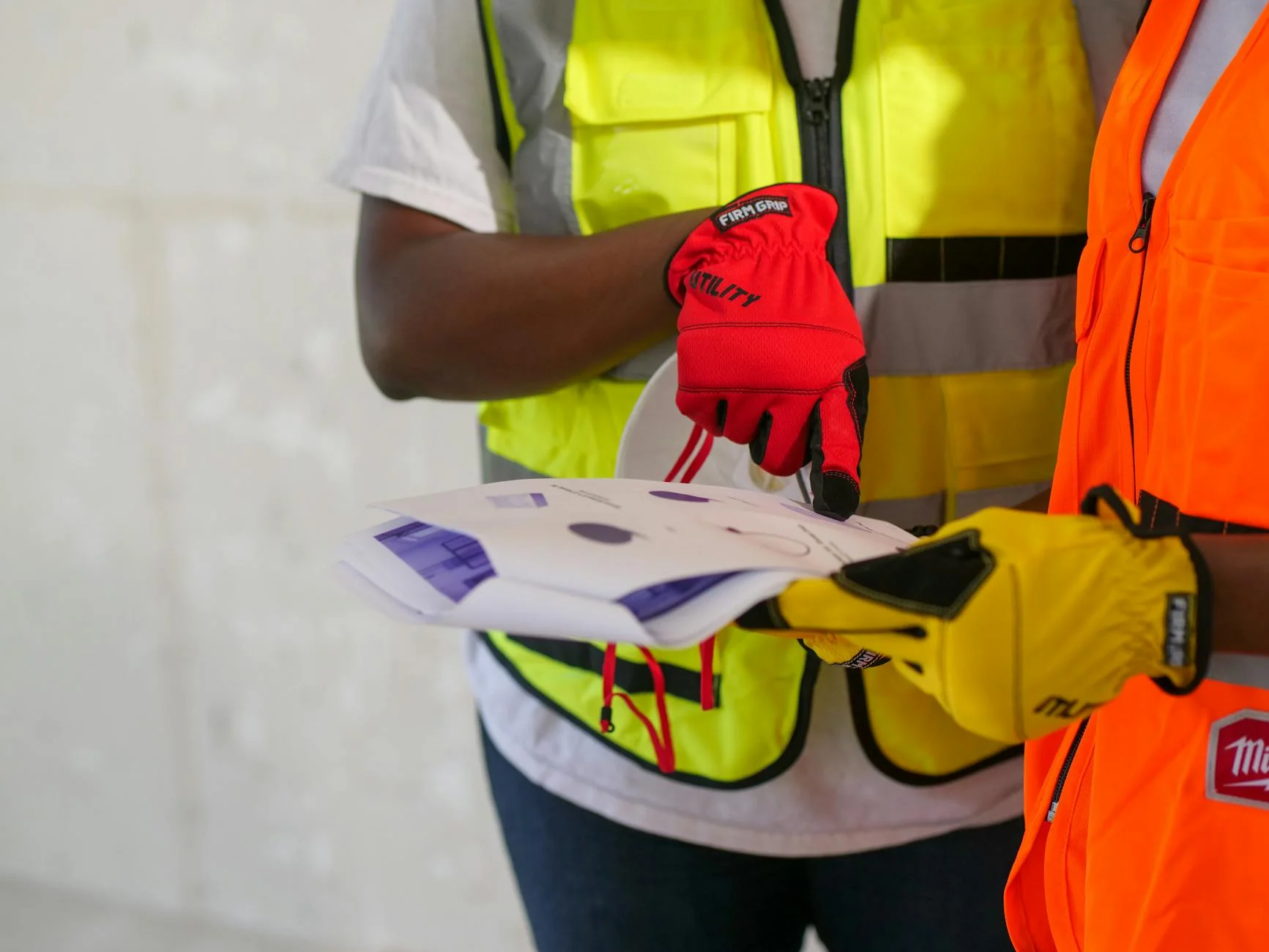 Subcontractor reviewing a progress-payment lien waiver on a phone next to a monthly pay application on a job site