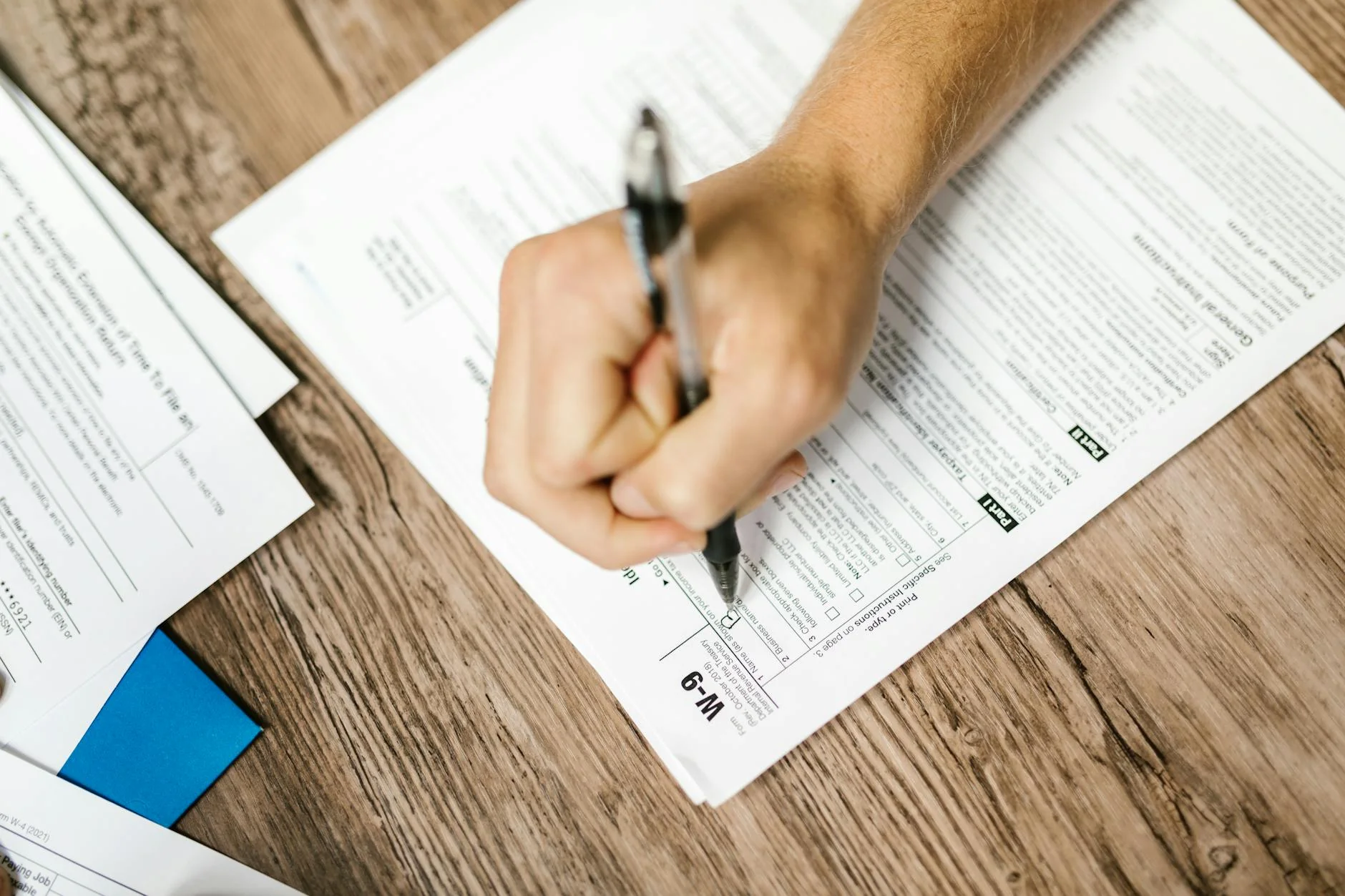 A subcontractor sitting in a pickup truck filling out a paper lien waiver on a clipboard