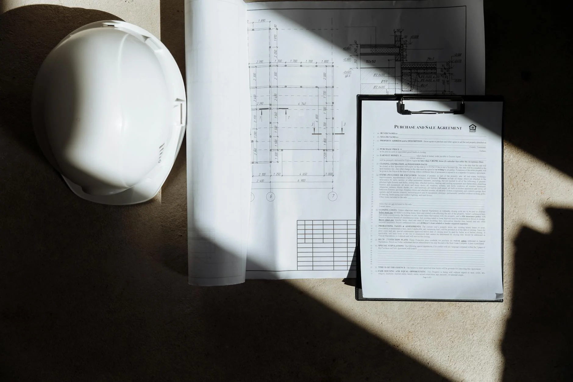Construction crew on an active jobsite reviewing payment paperwork at a folding table